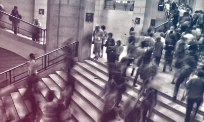 people blurred moving through building