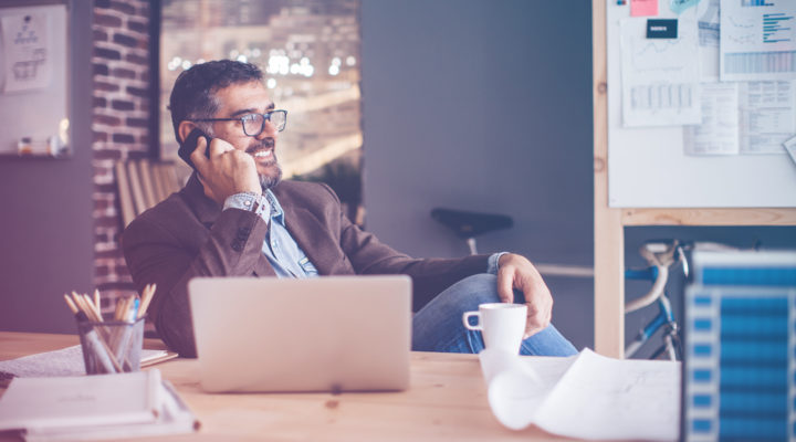 man on phone at laptop